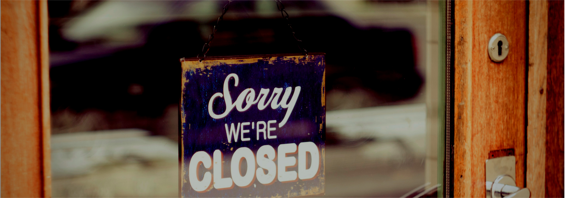 A closed sign hangs in a business window.