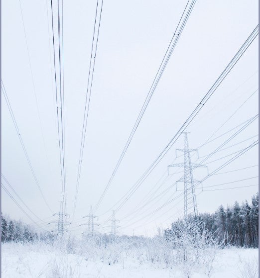Transmission lines running through a snowy field 