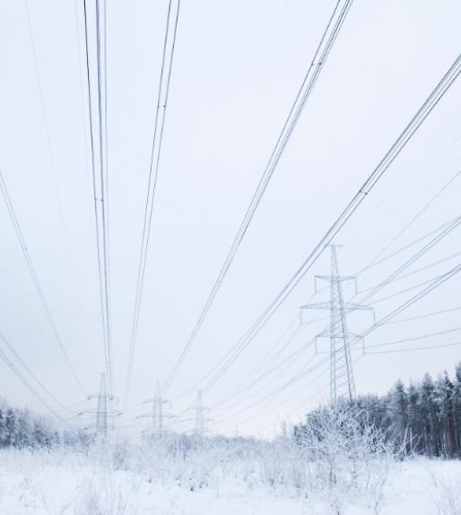 Transmission lines running through a snowy field 